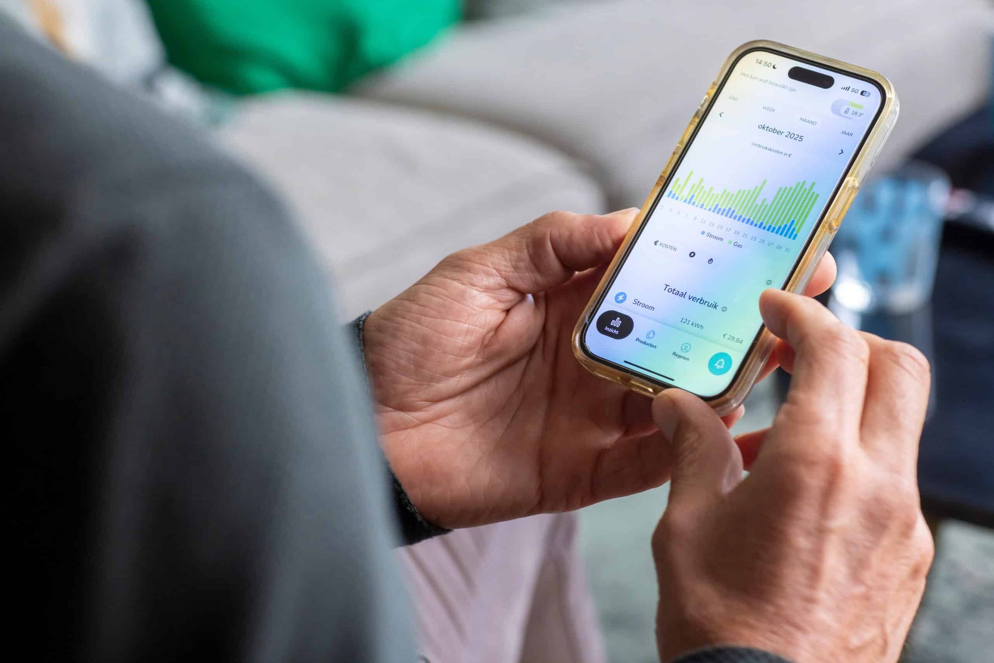 Handen houden smartphone met energie-verbruiksgrafieken en verbruiksgegevens